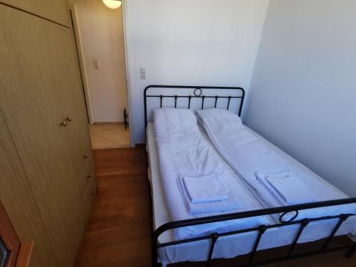 Cama pequeña en habitación con puerta en Oliana Apartments, en Panormos Rethymno