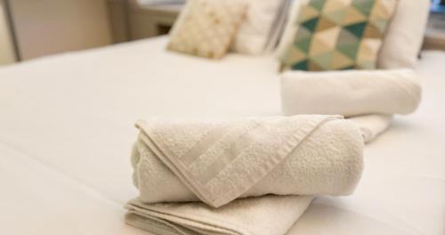 une pile de serviettes posée sur un lit dans l'établissement AC - Hypercenter - Close to Place Pie, à Avignon