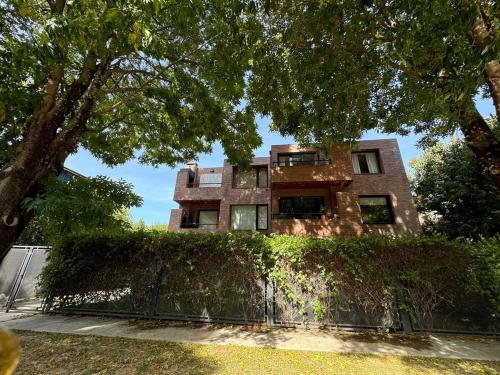 an old house with a hedge in front of it at Jardines de Fosbery in San Martín de los Andes