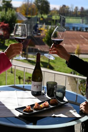 two people are holding glasses of wine at a table at Ancora Sport Resort Hotel in Meolo