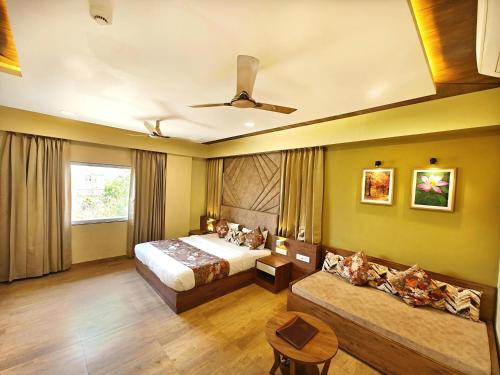 a hotel room with a bed and a couch at Opulence Inn - 500 Meters From Railway Station in Udaipur