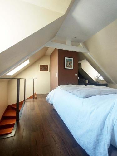 une chambre avec un grand lit dans un grenier dans l'établissement Maison sur port vue mer imprenable, à Binic