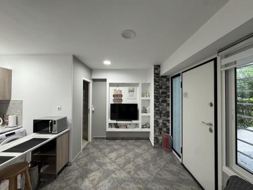 a kitchen with white walls and a large window at Aphrodite Studio near Athens Floisvos Marina in Athens