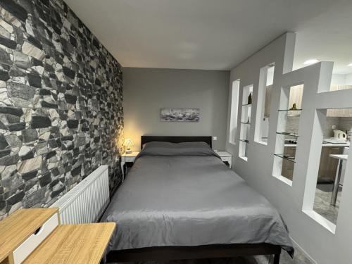a bedroom with a bed and a stone wall at Aphrodite Studio near Athens Floisvos Marina in Athens