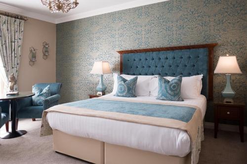 a bedroom with a large bed with a blue headboard at Clanard Court Hotel in Athy
