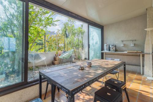 une cuisine avec une table et une grande fenêtre dans l'établissement L'Escapade Méditerranéenne, à Marseille