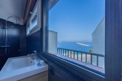 La salle de bains est pourvue d'une fenêtre offrant une vue sur l'océan. dans l'établissement L'Escapade Méditerranéenne, à Marseille