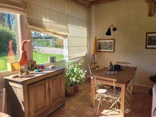 une cuisine avec une table et une table et une fenêtre dans l'établissement Chaumière Normande, à Pierrefiques