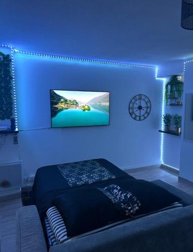 Cette chambre bleue comprend un lit et une télévision murale. dans l'établissement Le Maya Savana, à Marseille