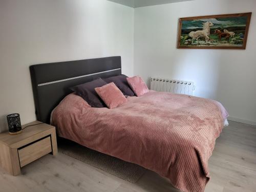 - une chambre dotée d'un lit avec des draps roses et une photo dans l'établissement Maison de Louna, à Noailles