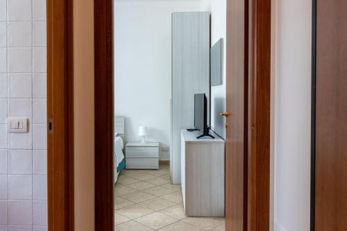 a room with a television on a dresser and a bedroom at Andrea's Dépendance in Letojanni