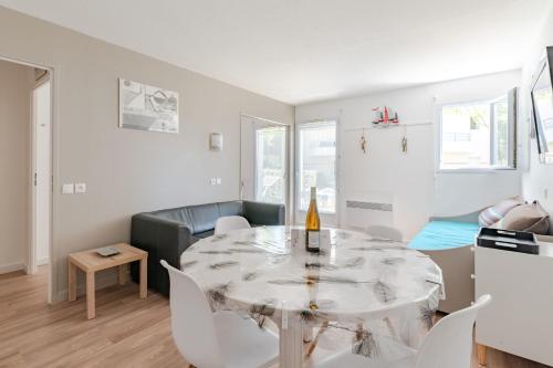 un salon blanc avec une table et des chaises dans l'établissement Le Green - T2WifiMer, à Pornic