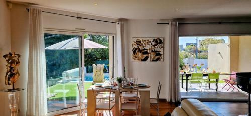un salon avec une table et une salle à manger dans l'établissement VILLA LA MAZAL, Bord de Mer, Piscine, Double Baignoire Balneo, Climatisation, à Sète