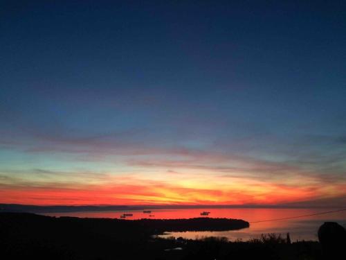 a sunset over a body of water with boats in it at SunSeaPoolsideStudio CasaSolare VistaMare in Muggia
