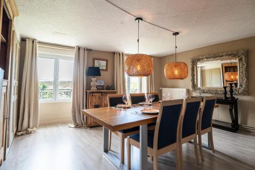 Un comedor con mesa y sillas de madera. en La Maison de la Liberte, en Laferté-sur-Amance