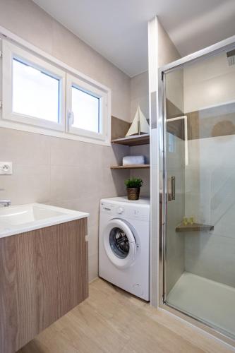 une salle de bain avec une machine à laver et un lavabo dans l'établissement Appart4 pers clim parking piscine, à Antibes