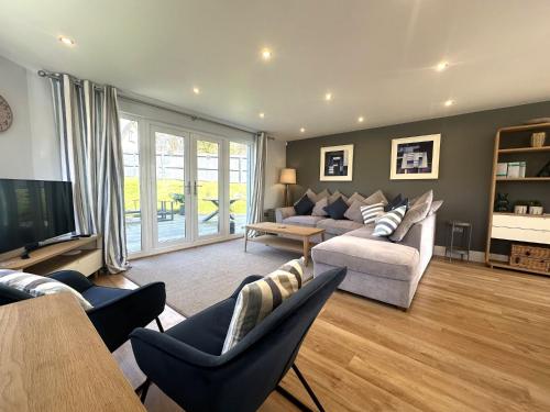 a living room with a couch and a tv at Trewhiddle Retreat V14 by Together Travel - Luxury 4-Bedroom Villa in St Austell
