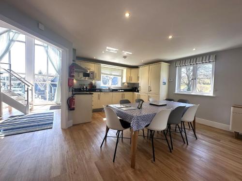 a kitchen and dining room with a table and chairs at Trewhiddle Retreat V14 by Together Travel - Luxury 4-Bedroom Villa in St Austell