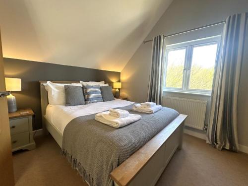 セント・オーステルにあるLuxurious 4 Bedroom New England Style Villa - Trewhiddle V14のタオルが敷かれたベッドのある寝室