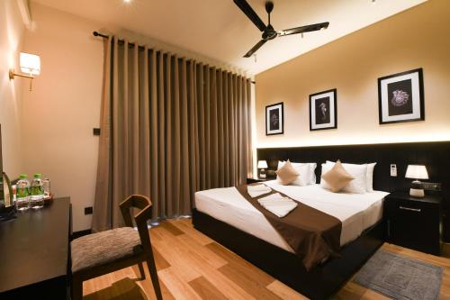 a bedroom with a bed and a desk and a chair at Hiriketiya Beach Resort in Hiriketiya