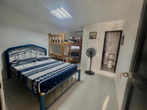a bedroom with a blue bed and a fan at Casa grande cerca a la playa in Ríohacha