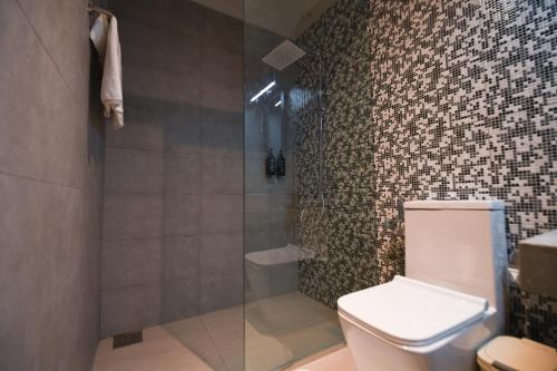 a bathroom with a toilet and a glass shower at Hiriketiya Beach Resort in Hiriketiya