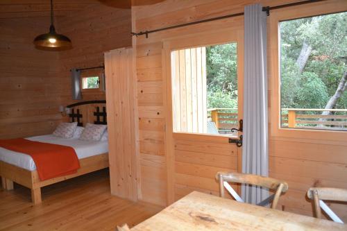 Кровать или кровати в номере Les Cabanes Dans Les Bois Logis Hôtel