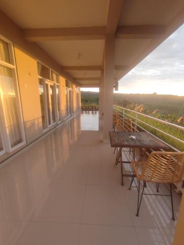 a balcony with a table and benches on a building at Gunza Bed and Breakfast in Jatiluwih