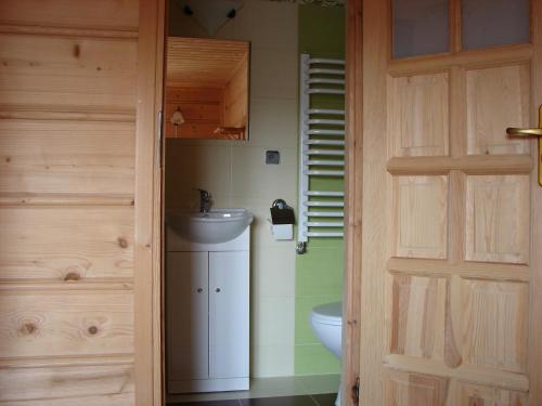 a bathroom with a sink and a toilet and a door at Pokoje u Małgorzatki in Murzasichle