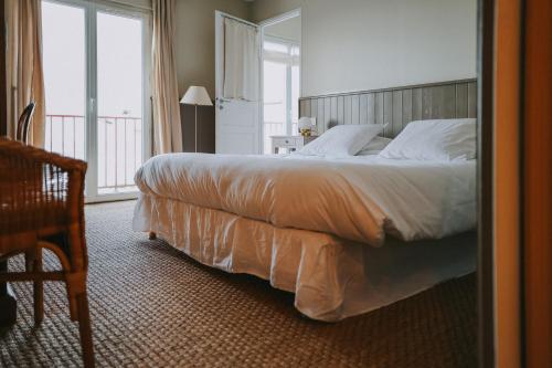 a bedroom with a large bed and a balcony at Rivage, Chambres et Table in Saint-Pierre-Quiberon