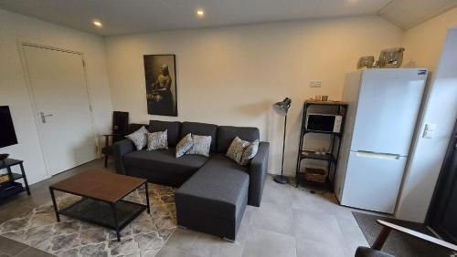 a living room with a couch and a refrigerator at Haarle's kleine landhuis NR 1 in Haarle