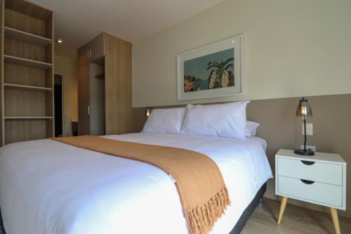 a bedroom with a large white bed with a night stand at Pod by Wynwood House in Lima