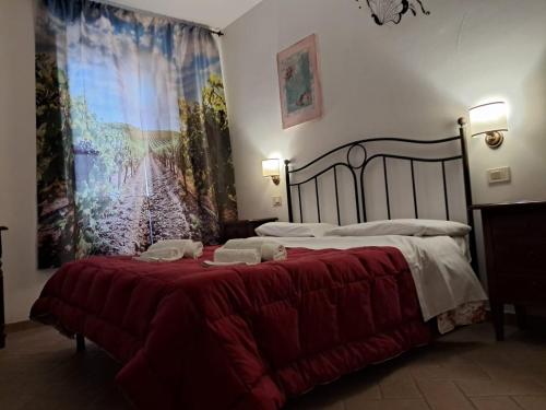 a bedroom with a large bed with a red blanket at 8380 Agriturismo il Saragiolo in Manciano