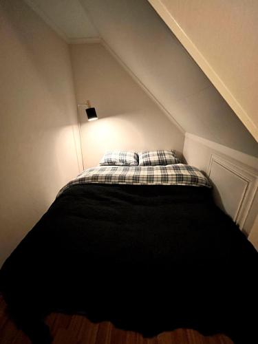 a bed in a small room with a ceiling at Cozy house with sea view in Havsteinen