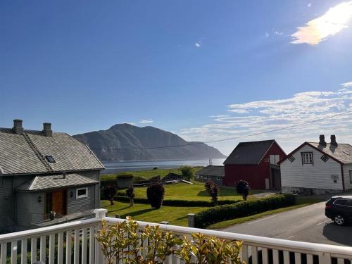 a view from a balcony of houses with mountains in the background at Cozy house with sea view in Havsteinen