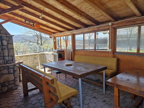 a porch with a wooden table and a bench at Villa Libero in Sarajevo