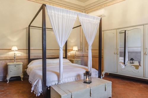 sypialnia z łóżkiem z baldachimem i zasłonami w obiekcie B&B Cortona Suite - Together in Tuscany w mieście Cortona