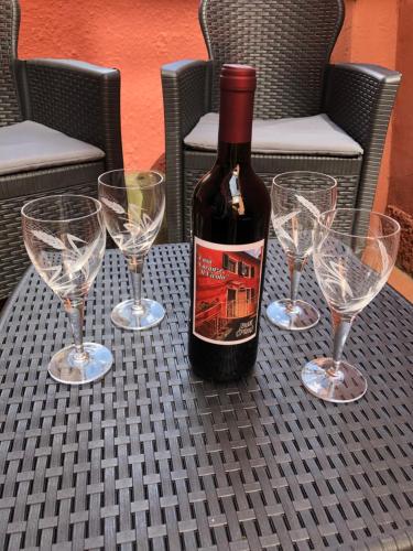 a bottle of wine sitting on a table with three wine glasses at Il Vicolo in Buti