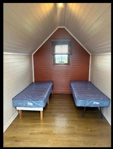 two beds in a small room with a window at Seaview Holiday Park in Penzance