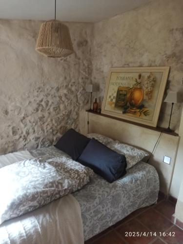 een slaapkamer met een bed en een schilderij aan de muur bij Notre Cabanon en Provence in Auriol