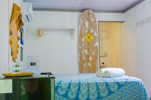 a room with a bed and a surfboard on the wall at Olivia del caribe suite in Puerto Viejo