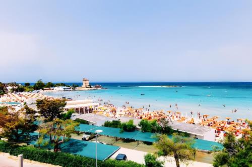 a beach with a lot of people in the water at Isid'Oro Rooms - 100m from the sea in Sant'Isidoro