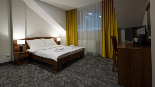a hotel room with a bed and a television at Forrest in Głogów Małopolski