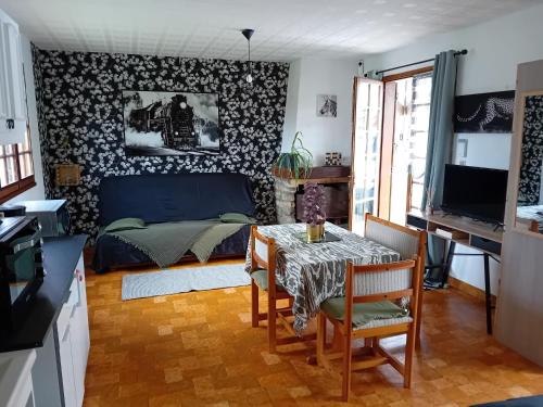 un salon avec une table et une chambre dans l'établissement Petite maison, à Messei-Saint-Gervais