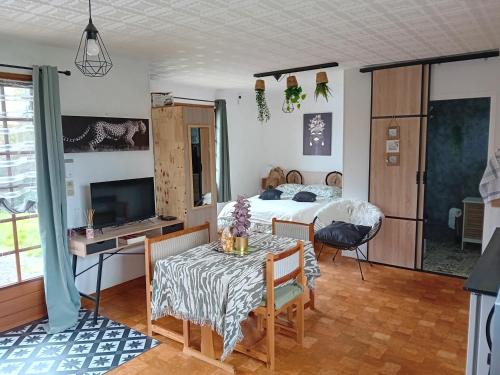 une chambre avec un lit, une table et une télévision dans l'établissement Petite maison, à Messei-Saint-Gervais