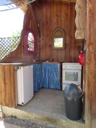 - une cuisine dans une maison avec une poubelle dans l'établissement Groovy Caravane, à Montbrun-Bocage