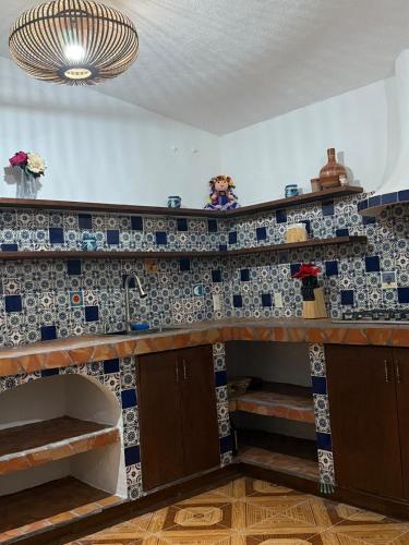 a kitchen with a counter with blue and white tiles at Casa con Alberca La Mexicana in La Calera