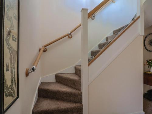 a staircase with wooden railings in a house at Fig Tree House in Axminster