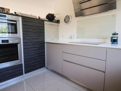 a kitchen with white counters and a stove top oven at Fig Tree House in Axminster