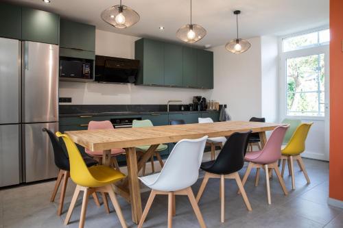 une cuisine avec une table et des chaises en bois dans l'établissement Chambre dans maison cosy, à Château-Gontier